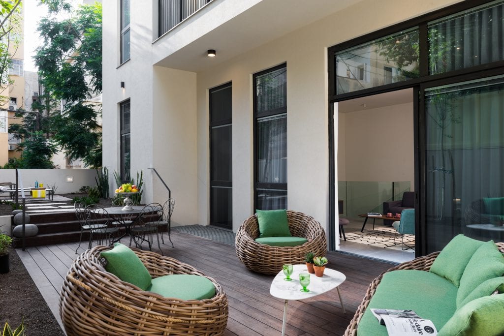 Spacious private garden in the Five-Bedroom Duplex Garden at master Shenkin Tel Aviv, featuring stylish outdoor furniture for relaxation.
