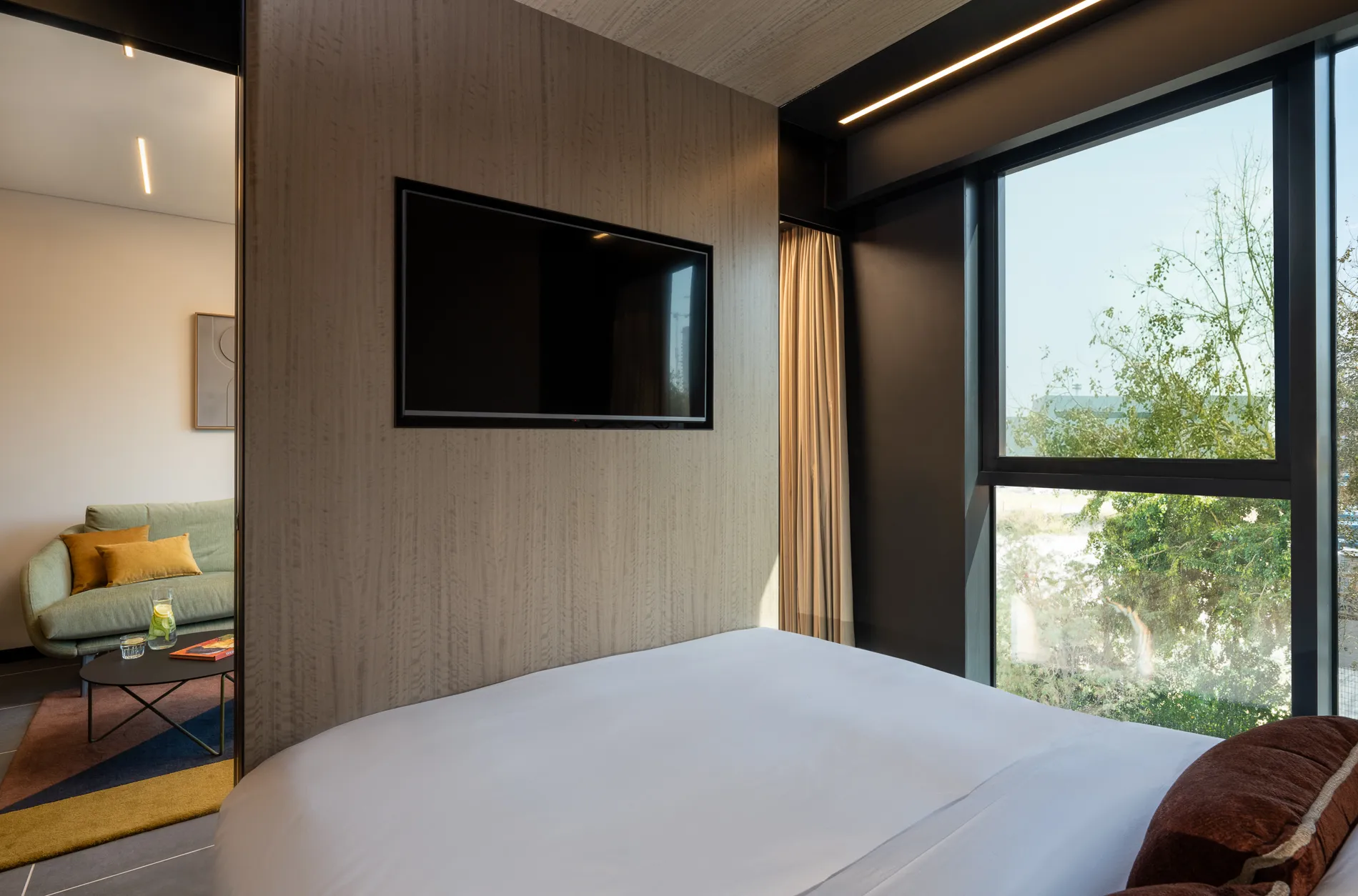 Cozy bed in the One-Bedroom Suite at master Bat Yam, designed for ultimate comfort with soft linens and a warm, inviting ambiance.