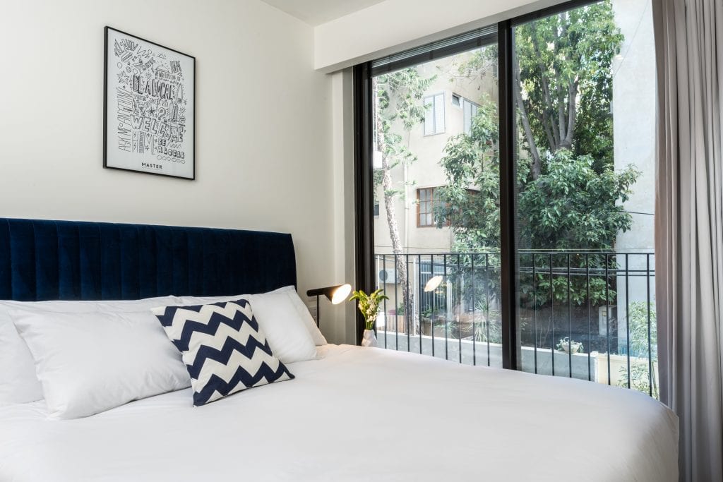 Cozy sleeping area in the One-Bedroom Apartment with Balcony at master Shenkin Tel Aviv, designed with soft linens and modern decor for ultimate comfort
