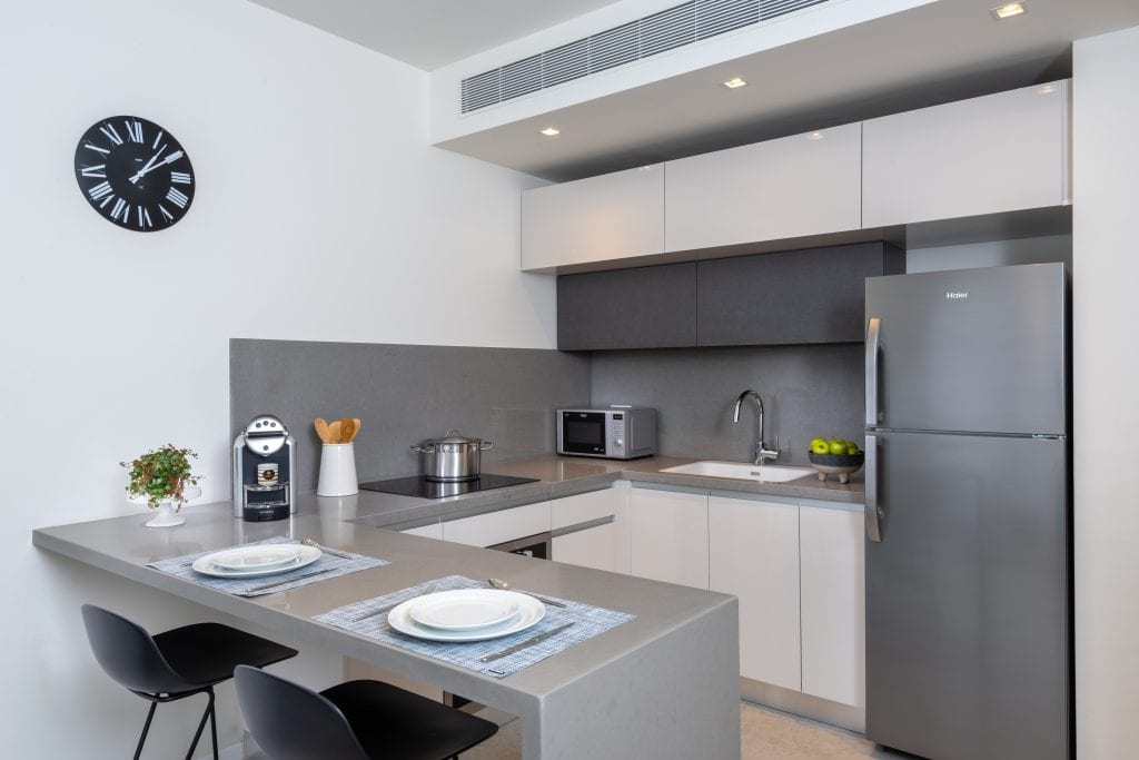Compact and functional kitchenette in the One-Bedroom Apartment at master Shenkin Tel Aviv, blending convenience with contemporary design.