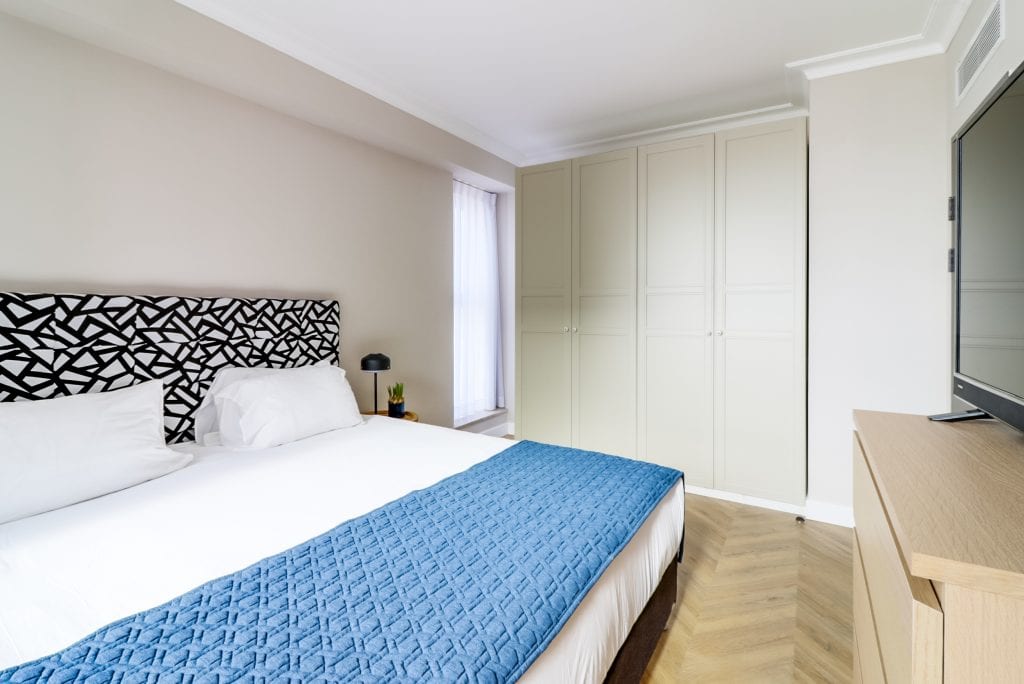 Cozy bedroom in the Two-Bedroom Seaview Apartment at master Haifa, featuring a comfortable bed and a warm, inviting ambiance.