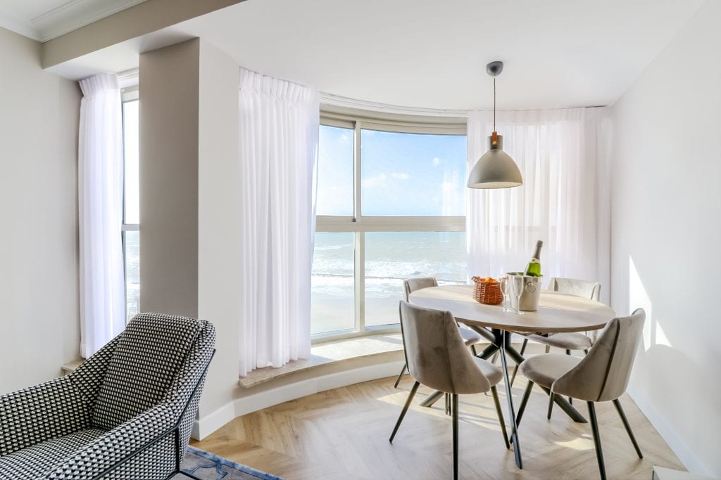 Elegant dining area at master Haifa, featuring a modern table and a large window with stunning sea views.