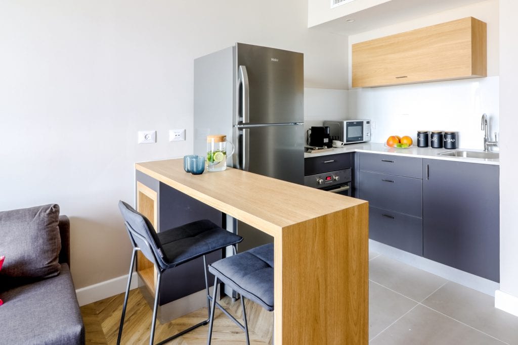 Fully equipped kitchen in the One-Bedroom Seaview Apartment at master Haifa, featuring modern appliances and a functional layout.