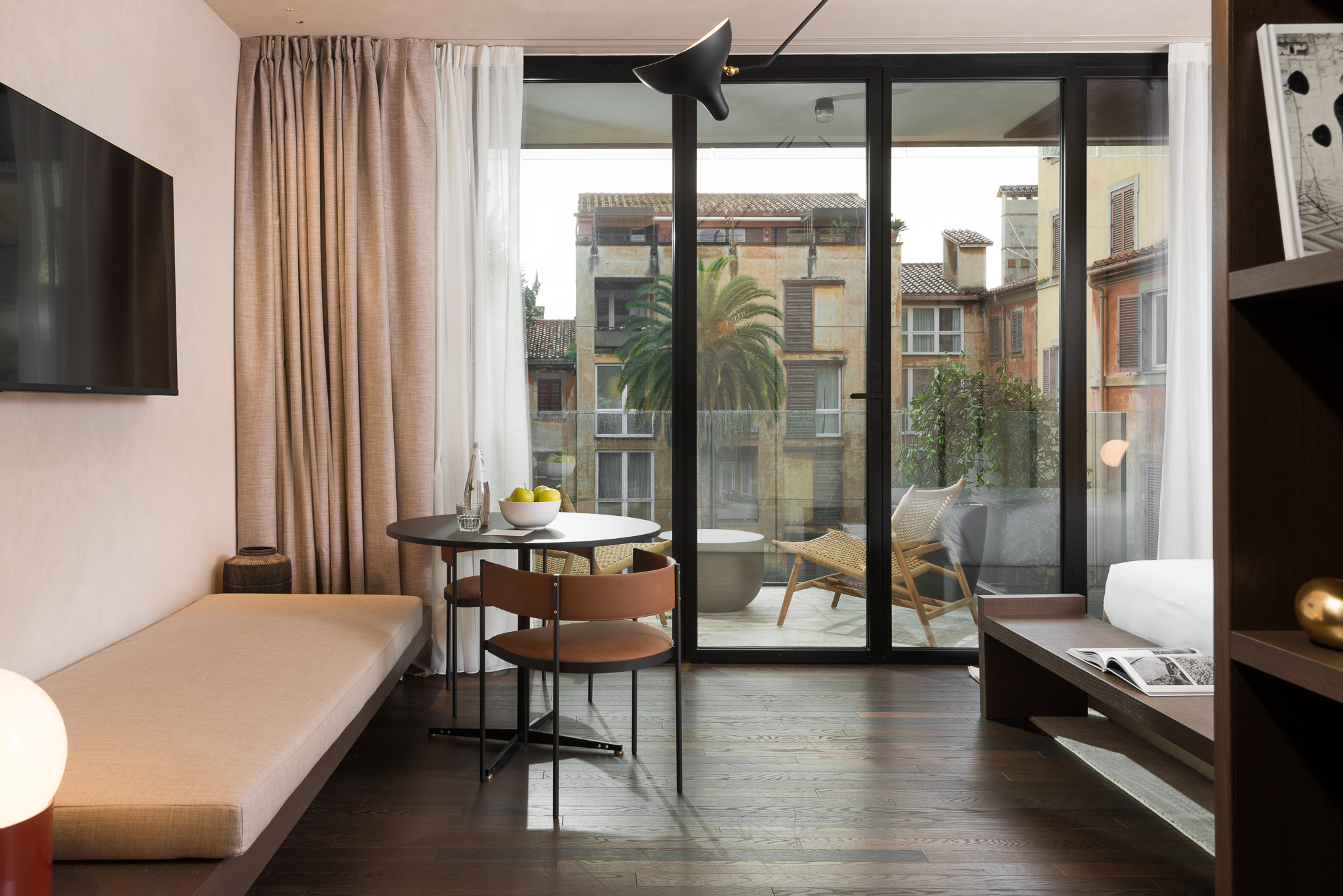 Comfortable and inviting living area in the Studio with Balcony at master Trevi Rome, designed for relaxation with access to fresh air and natural light.