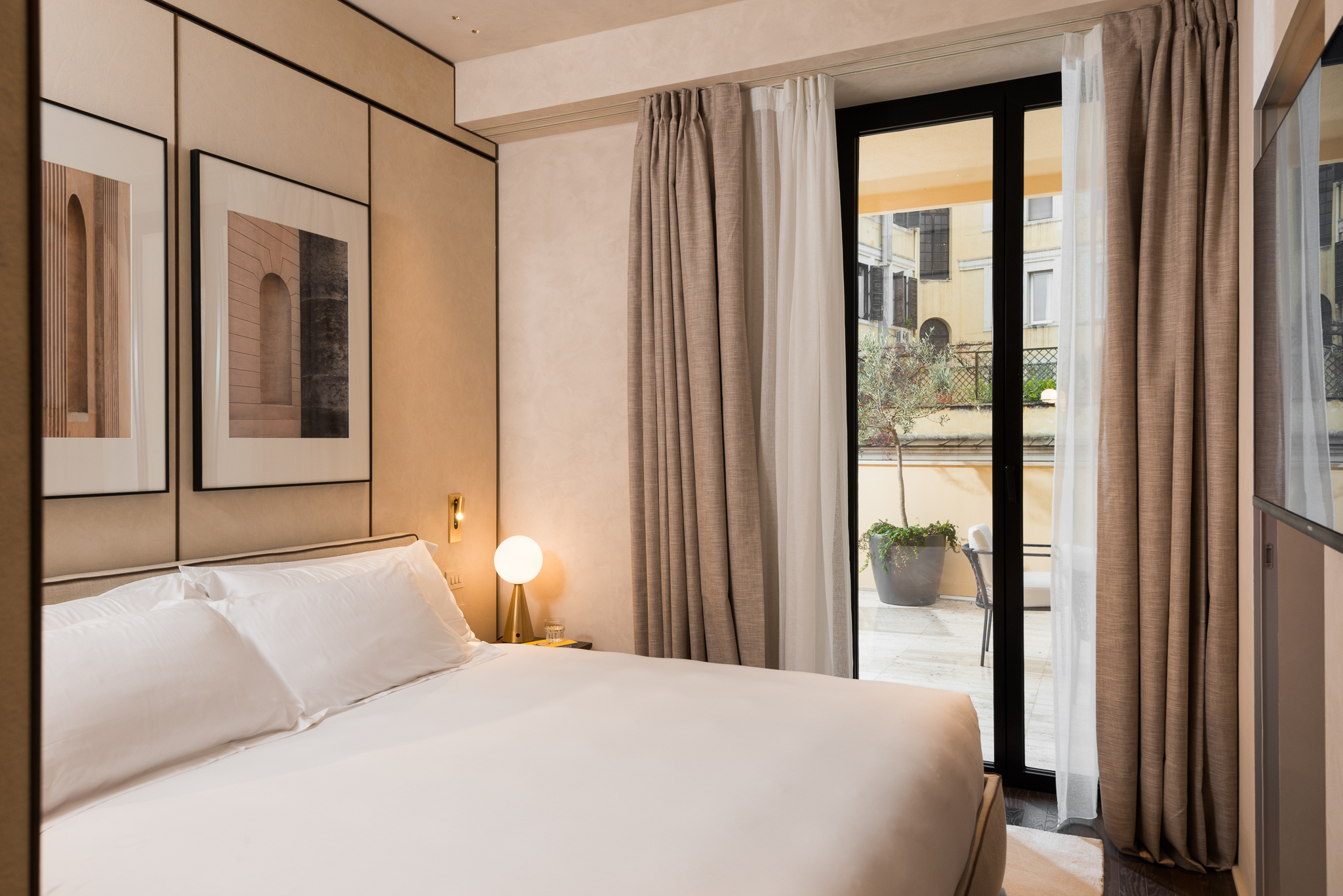 Elegant bedroom in the One-Bedroom Apartment with Big Terrace at master Trevi Rome, featuring a cozy bed and direct access to a spacious balcony.