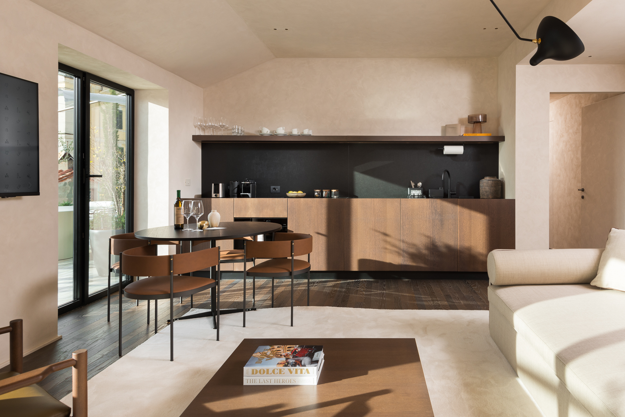 Bright and stylish living area in the Two-Bedroom Penthouse at master Trevi Rome, with a glass door leading to the private balcony.