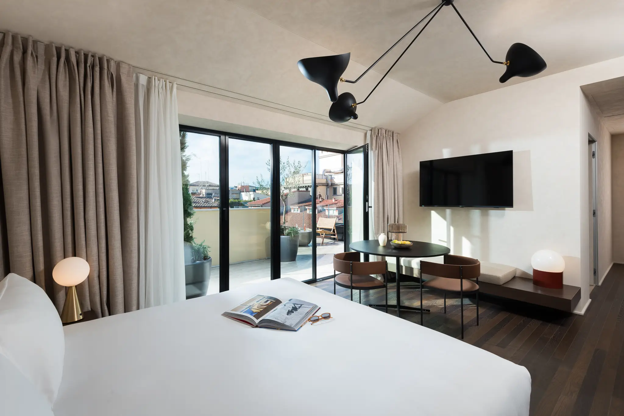 Elegant bedroom in the Three-Bedroom Penthouse at master Trevi Rome, featuring a plush bed and direct access to a private balcony.