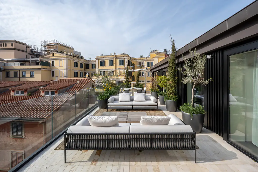 Penthouse terrace at master Trevi Rome Aparthotel featuring stylish outdoor seating and sweeping views of Rome